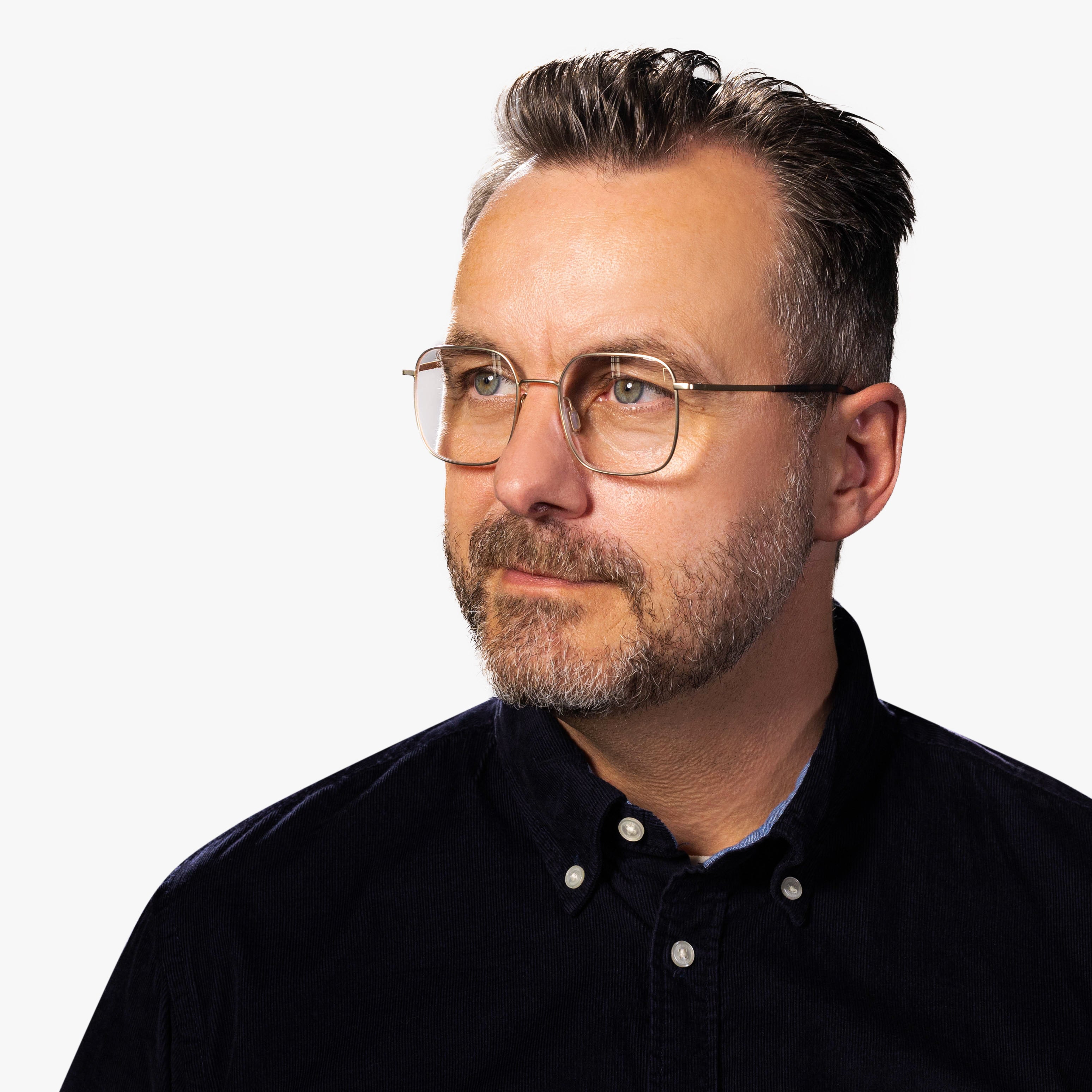 Person wearing Båstad Gold glasses with square lenses and thin gold frames